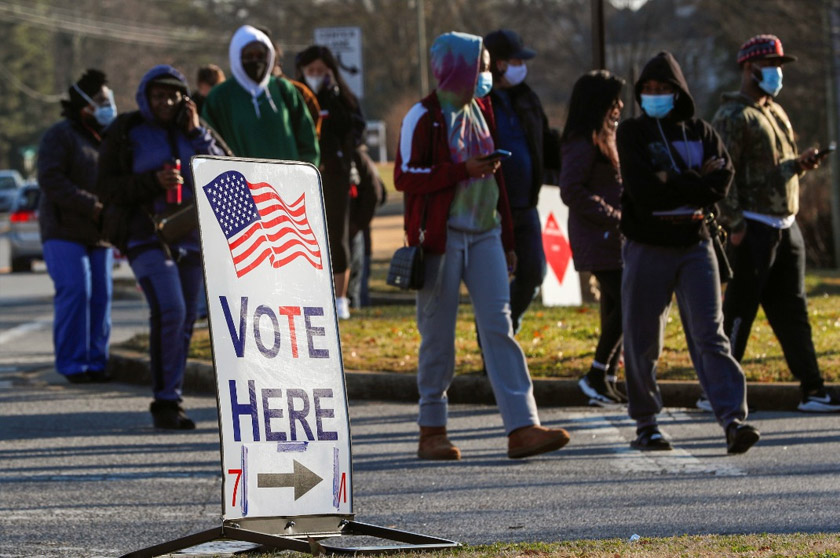A sign is seen as voters line up for the U.S. Senate run-off election, at a polling location in Marietta, Georgia, U.S., January 5, 2021. REUTERS/Mike Segar