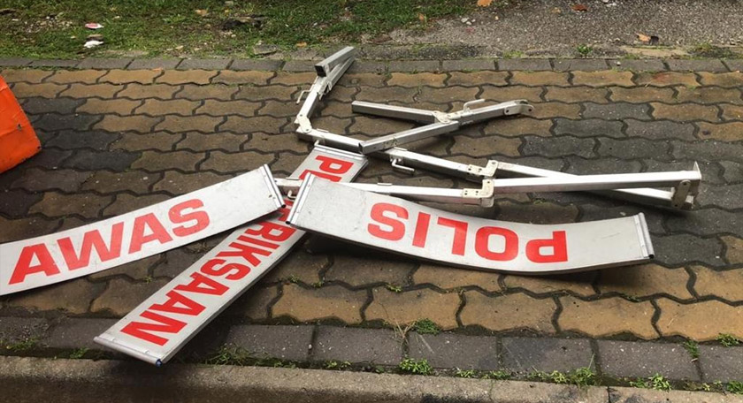 Akibat kejadian tersebut papan tanda ‘Pemeriksaan Polis’ mengalami kerosakan. 