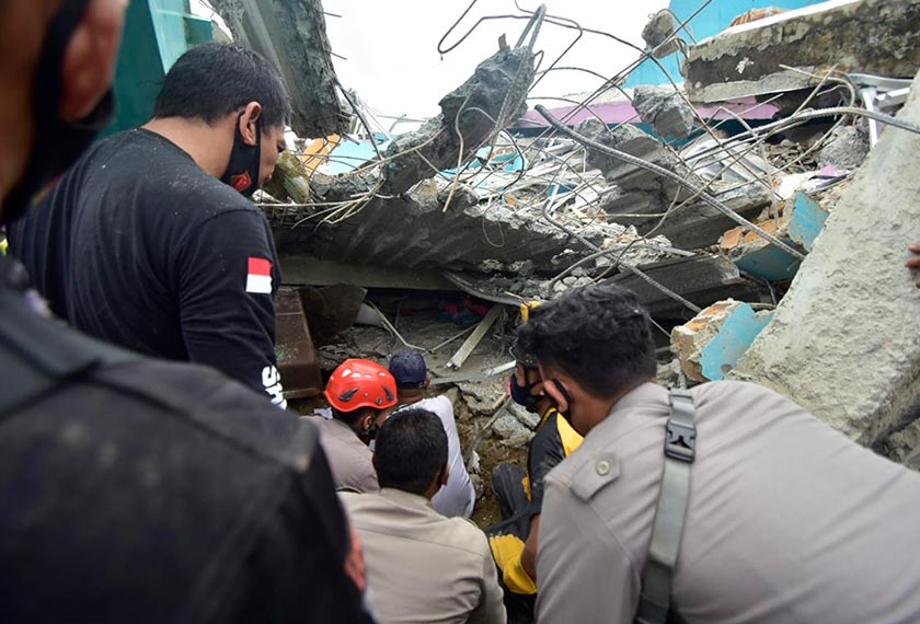 Rescuers search for survivors among the ruin of a building damaged by an earthquake in Mamuju, West Sulawesi, Indonesia, Friday, Jan. 15, 2021. (AP Photo/Daus Thobelulu)