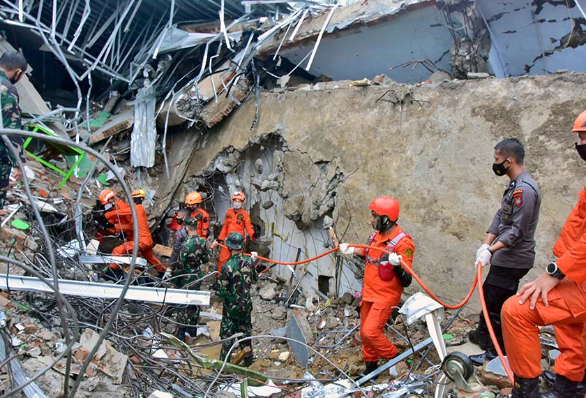 Rescuers search for survivors at the ruin of a government building collapsed during an earthquake in Mamuju, West Sulawesi, Indonesia, Friday, Jan. 15, 2021. (AP Photo/Daus Thobelulu)