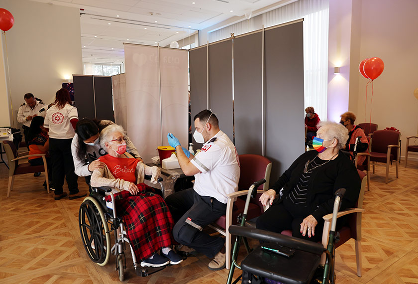 Residents of an assisted living facility receive their booster shot of the vaccination against the coronavirus disease (COVID-19) during a party celebrating the residents receiving their second dose of the vaccine, in Netanya, Israel January 19, 2021. REUTERS/Ronen Zvulun