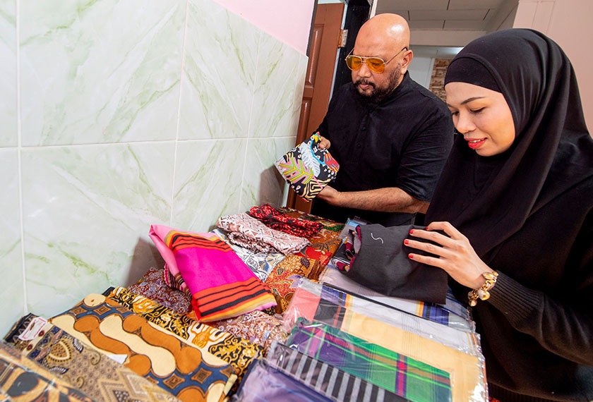 Mohd Rosoliza dan isteri memilih seluar 'Separuh Rindu' untuk dihantar kepada pelanggan. --fotoBERNAMA