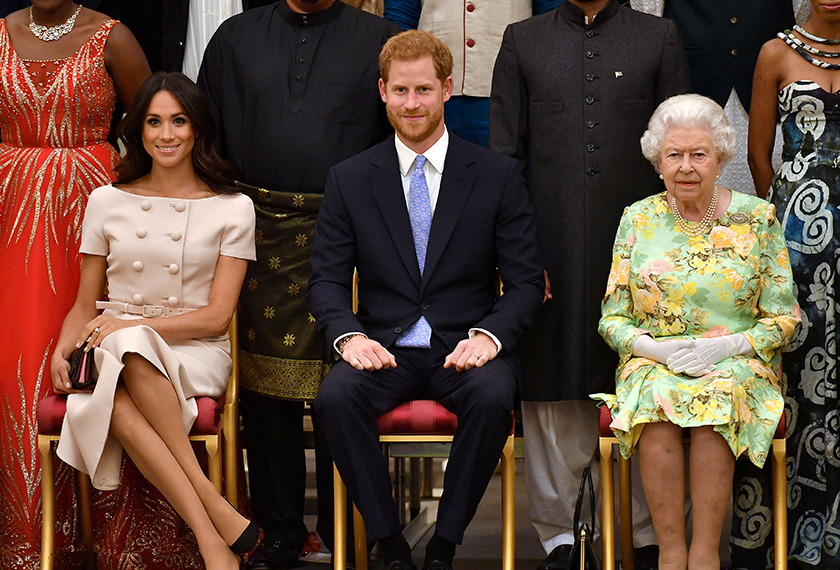 Britain's Queen Elizabeth, Prince Harry and Meghan, the Duchess of Sussex pose for a picture with some of Queen's Young Leaders at a Buckingham Palace reception following the final Queen's Young Leaders Awards Ceremony, in London, Britain June 26, 2018. John Stillwell/Pool via Reuters/File Photo