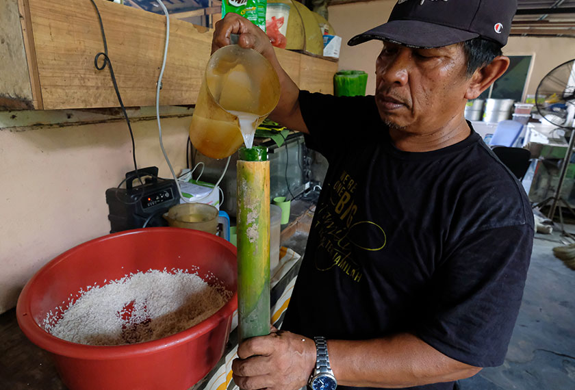 Zainal Abidin memasukkan santan ke dalam buluh lemang. --fotoBERNAMA