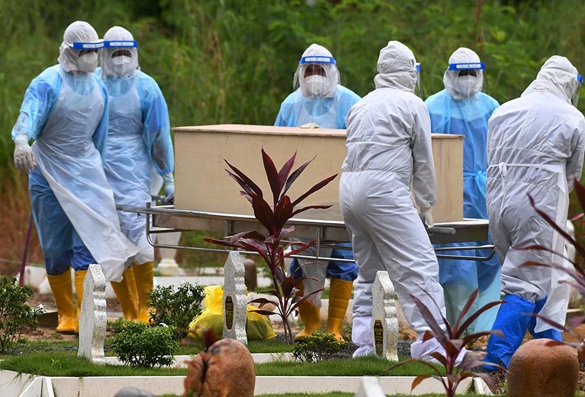  Petugas pengurusan jenazah pesakit COVID-19 menurunkan jenazah seorang mangsa di Tanah Perkuburan Islam Setali untuk dikebumikan sehari sebelum Aidilfitri hari ini. - Foto Bernama