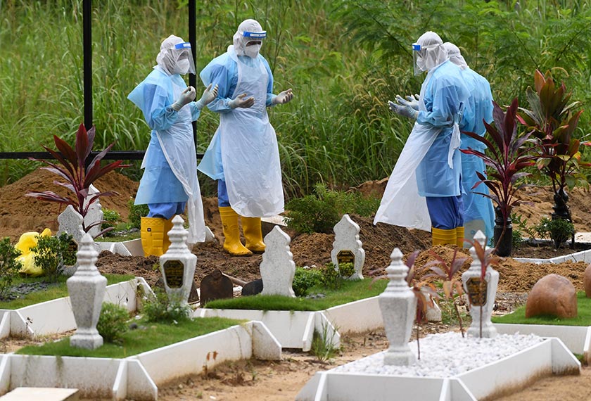 . Petugas pengurusan jenazah pesakit COVID-19 bersama-sama mengaminkan doa ketika menguruskan pengkebumian seorang mangsa di Tanah Perkuburan Islam Setali sehari sebelum Aidilfitri hari ini. - Foto Bernama