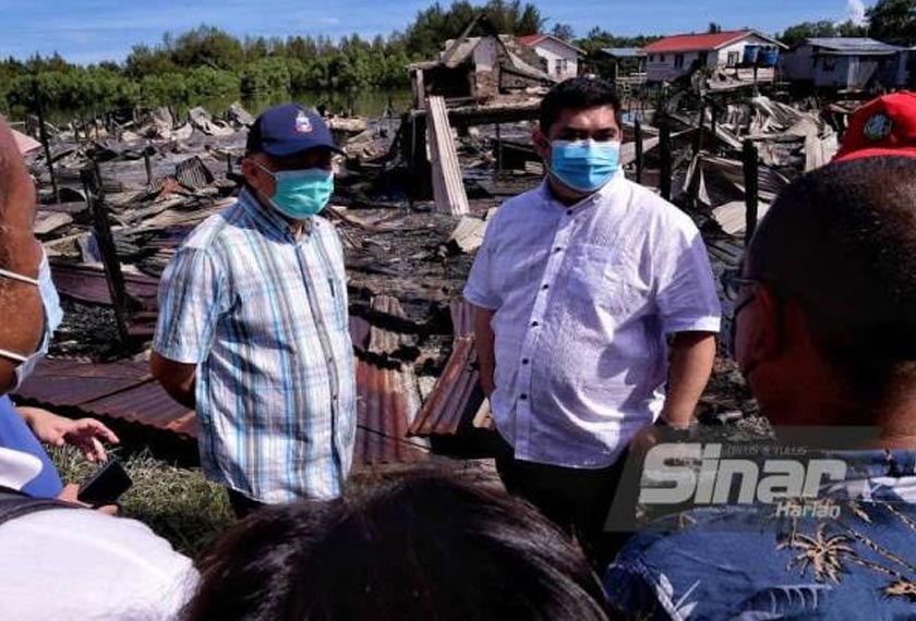 Shahelmey (kanan) dan Arifin (kiri) hadir meninjau lokasi kebakaran di Kampung Meruntum, Putatan pada Ahad. - Foto Sinar Harian
