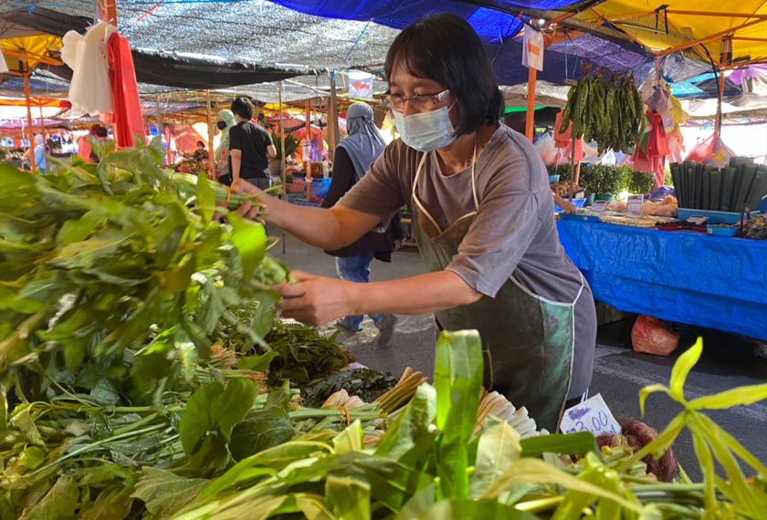 Diray Linnya menyusun sayuran yang dijual di Pasar Kubah Ria, Kuching.