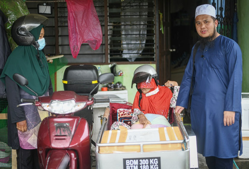 Tular sebelum ini wanita OKU tersebut menaiki motosikal beroda tiga, sambil menahan terik mentari. - Foto Facebook/Ebit Lew
