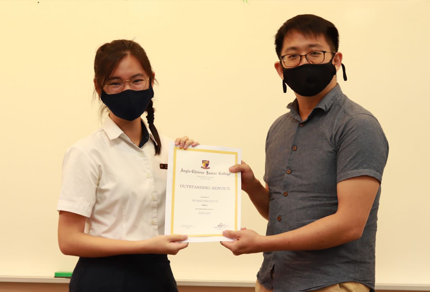  Alyssa menerima sijil pengiktirafan untuk ‘Outstanding Service Award’ dalam sumbangannya dalam aktiviti kokurikulum (Debat dan Persatuan Kebudayaan Melayu) daripada guru kelasnya Benjamin Lim di ACJC Singapura.