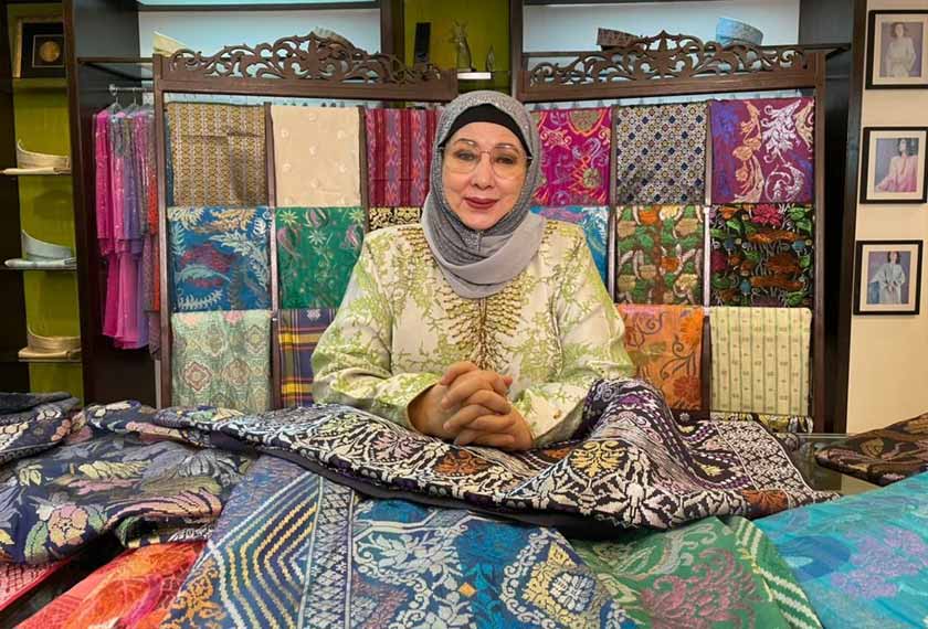 Kak Nik bersama koleksi songket tenunan Terengganu yang dihasilkan oleh anak tempatan melalui kaedah tradisi menggunakan alat tenunan - Gambar/AstroAWANI/HafiziRosli