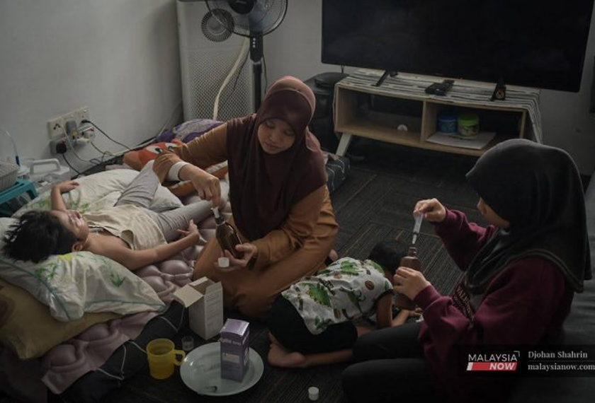 Zaitul Akma dibantu anak keduanya, Liyana, 15 mengisi ubat rutin harian pada picagari sebelum diberikan kepada dua anaknya di Damansara Damai.