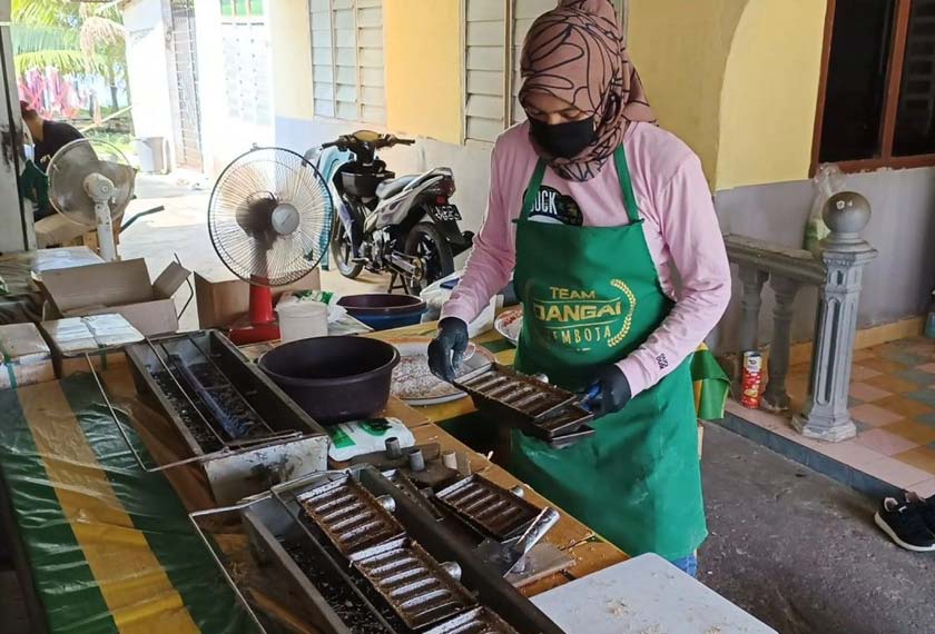 Che Elina sibuk memasak kuih dangai kemboja. - Gambar Astro AWANI
