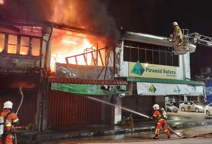 Tiga rumah kedai sederet di Pekan Parit Buntar terbakar awal pagi. - Foto JBPM