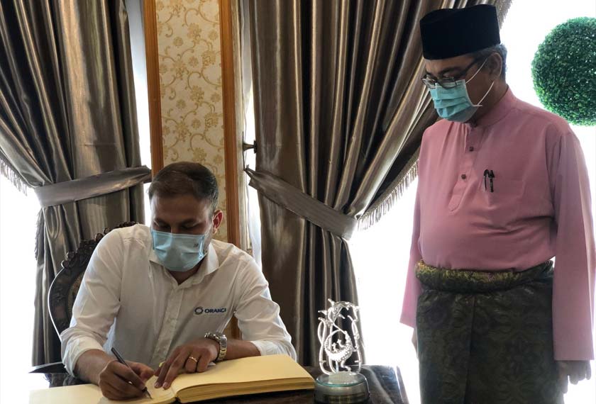 Oktay Keskin menandatangani buku pelawat sambil disaksikan Rumaizi. - Foto Astro AWANI