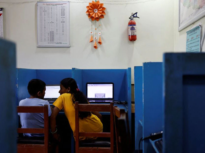 Parwati Sunar, 27, talks to her son Resham Sunar, 11, during a computer class at New World Vision Computer Institute, in Punarbas, Kanchanpur district, southwest Nepal. - REUTERS