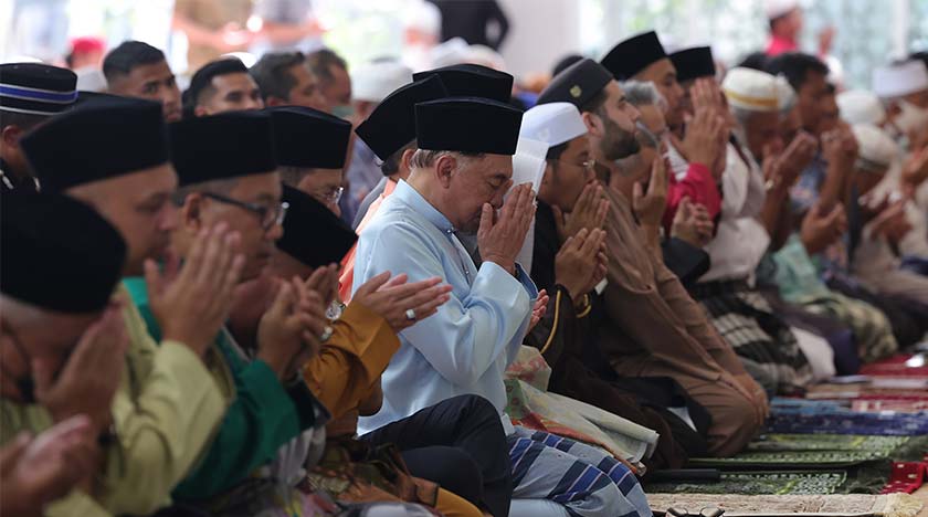 Perdana Menteri Datuk Seri Anwar Ibrahim mengaminkan doa yang dipimpin Imam Azizi Ab Hamid selepas menunaikan solat Jumaat di Masjid Jamek Kampung Baru hari ini. - Foto BERNAMA