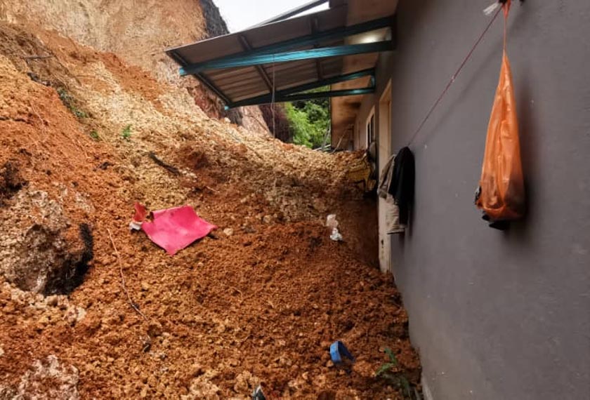 Keadaan rumah sewa didiami dua keluarga yang ditimbusi tanah runtuh di Kampung Mela, Lipis pada petang Sabtu.