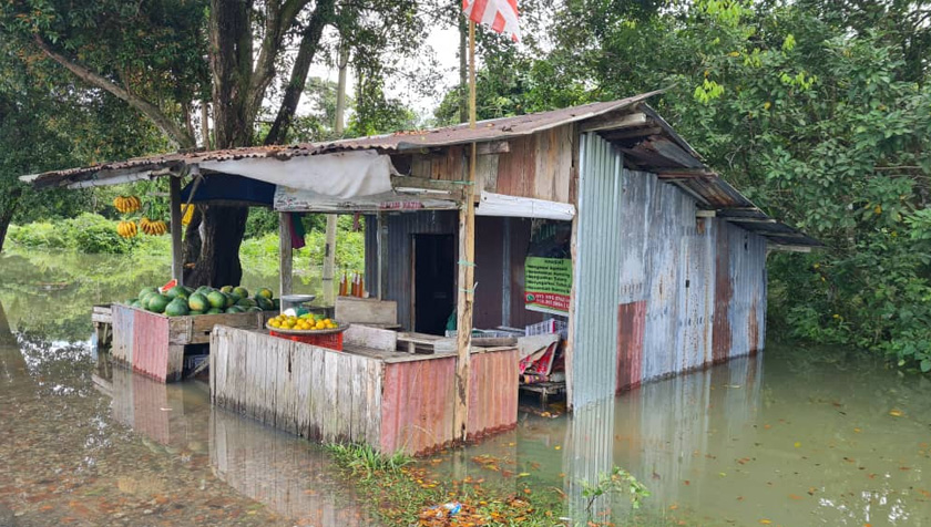 Meskipun dalam keadaan banjir, perniagaan perlu diteruskan disebabkan bekalan buah yang tidak boleh bertahan lama. - Foto Astro AWANI