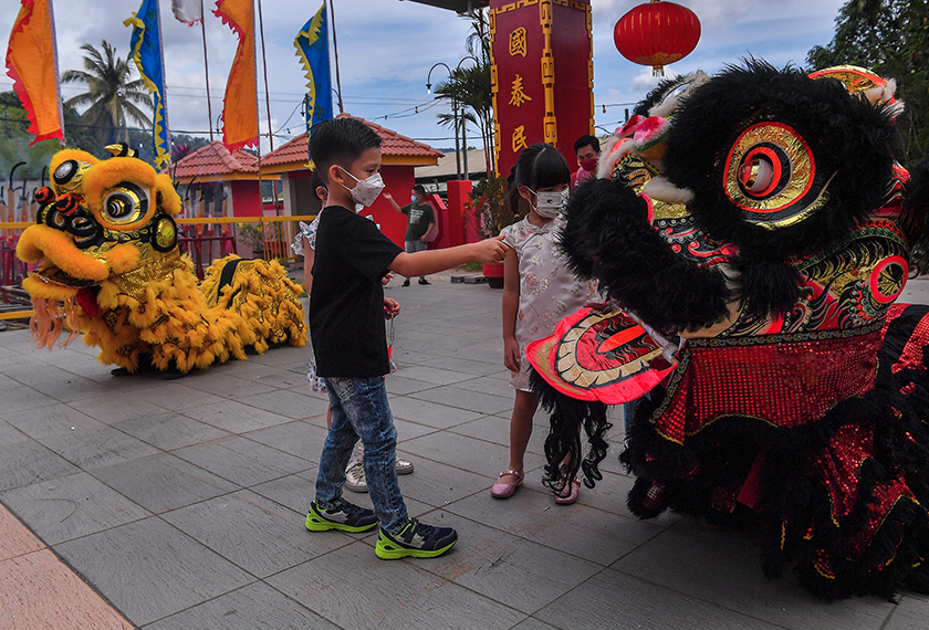 Kanak-kanak mendekati kostum tarian singa di Tokong Toh Guan Tien, Kuantan sempena sambutan Tahun Baharu Cina. - Bernama