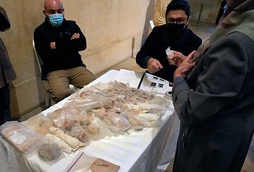 Pakar Iraq memeriksa barangan antik yang dipamerkan di Muzium Nasional Beirut sebelum 337 artifak diserahkan kepada duta Iraq, di Beirut, 6 Feb 2022. (Foto AP)
