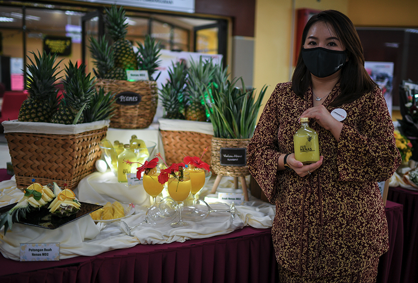 Peserta Program Modal Insan NCER Yew Zhi Shin menunjukkan hasil produk berasaskan nanas pada pameran yang dihadiri Perdana Menteri di Pejabat Daerah dan Tanah Padang Terap di Kuala Nerang pada Isnin lepas. --fotoBERNAMA