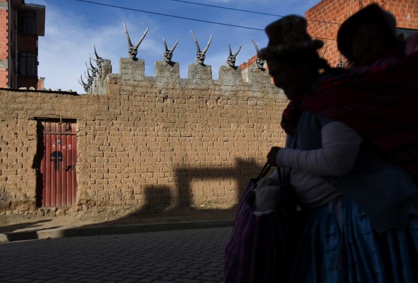 A woman walks past the house of Bolivian miner David Choque who has covered his house with sculptures of horned devils, intended as a playful nod to the South American country's colonial past, but which has shocked some neighbors and sparked allegations of occult rituals, in El Alto, Bolivia. - REUTERS