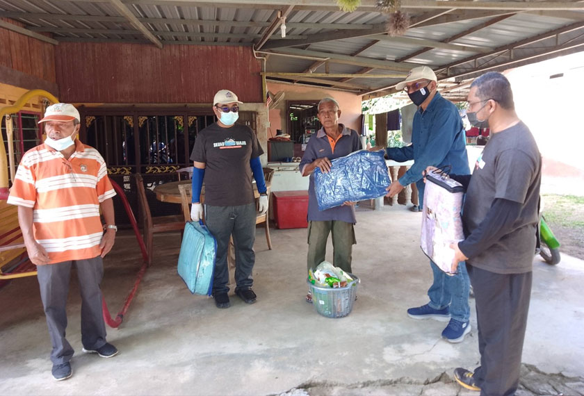 Badrul Hisham Darus (dua dari kanan) menyampaikan sumbangan kepada penduduk, Sahadan Samah, 70 diiringi Adam Ismail (kiri) pada Program Pasca Banjir VN37 bersama Universiti Malaysia Terengganu (UMT), hari ini. - Foto Astro AWANI