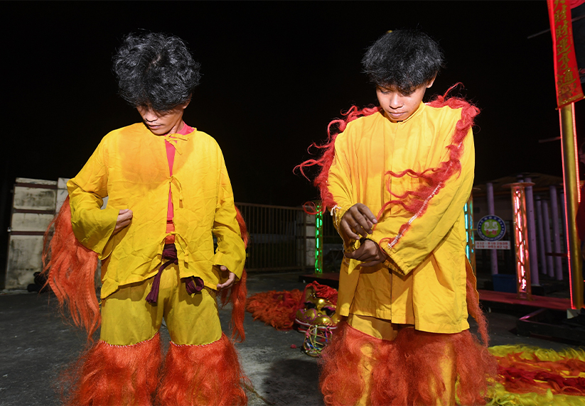 Penari Maisur Manistan (kiri) dan Ihwansyah Azroy memakai pakaian tradisi tarian singa sebelum memulakan latihan tarian singa di Kelab Sukan Leong Sin ketika ditemui baru-baru ini.