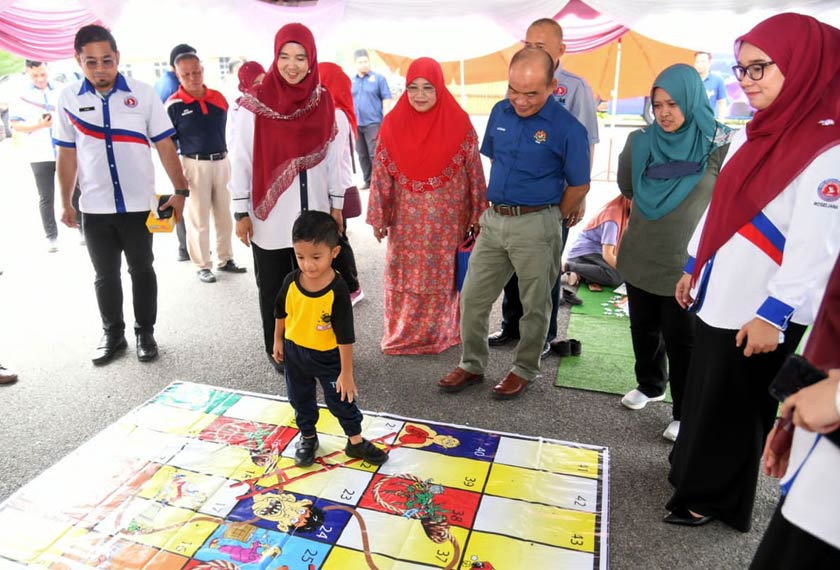 Sutekno (tengah) melihat gelagat kanak-kanak yang hadir menyertai aktiviti sempena Hari Pengekalan Kepulihan Klien AADK di Felda Keratong 3, Rompin, Pahang