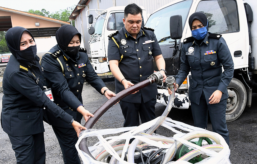 Ariffin bersama para anggotanya menunjukkan hos minyak yang digunakan oleh sindiket mengepam diesel bersubsidi pada sidang media di Nilai, 6 Julai 2022. --fotoBERNAMA
