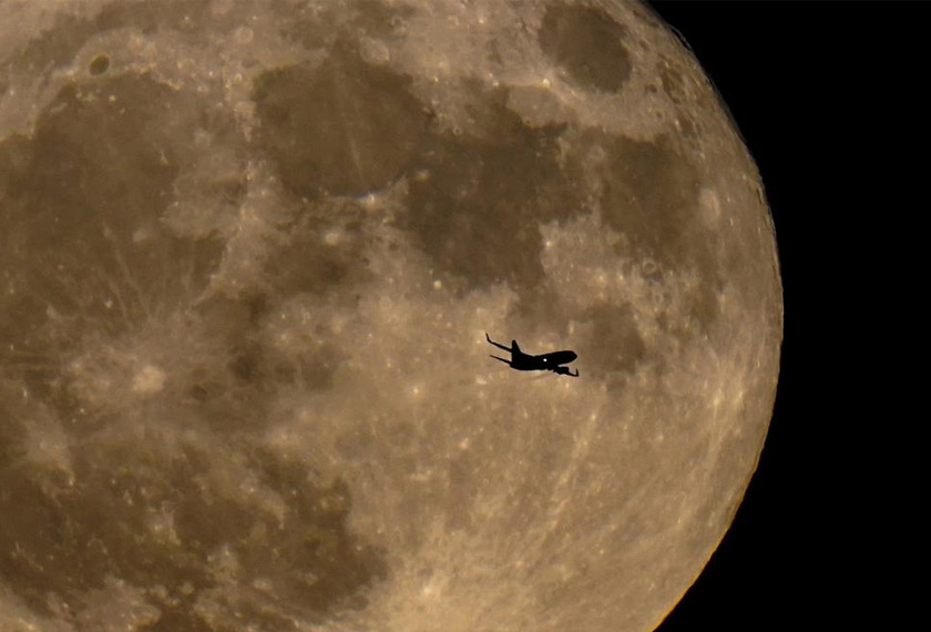 Sebuah pesawat melintasi ruang langit Milwaukee, Amerika Syarikat, berlatarkan fenomena ‘supermoon’ pada 13 Julai 2022. - AP