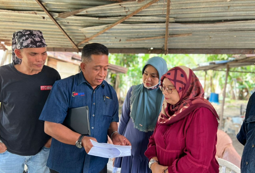 Azman (dua dari kiri) hadir mendapatkan dokumen bagi permohonan rumah baharu untuk Zawani. Foto/Astro AWANI