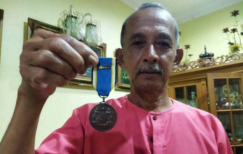 Tok Lan menunjukkan pingat yang diterima.