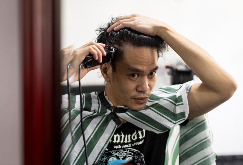 Artist and Filipino seafarer Jesstoni Garcia shaves his hair to create a portrait, in San Juan City, Philippines. - REUTERS