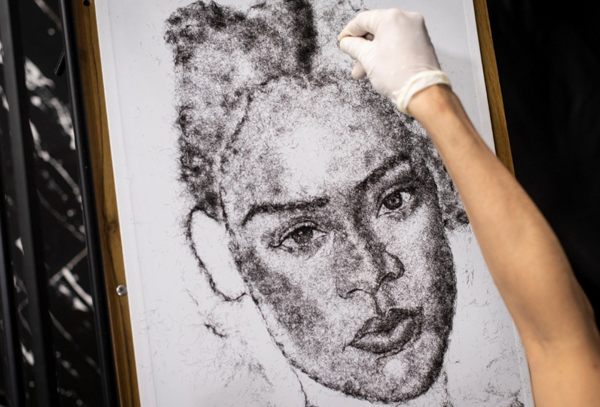 Artist and Filipino seafarer Jesstoni Garcia works on a portrait of Rihanna, made out of human hair, in San Juan City, Philippines. - REUTERS