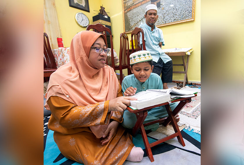 Zawati mengajar mengaji kepada anaknya ketika ditemui di rumahnya di Kampung Chekok, Jalan Rambutan Rendang, Kota Bharu, baru-baru ini. --fotoBERNAMA