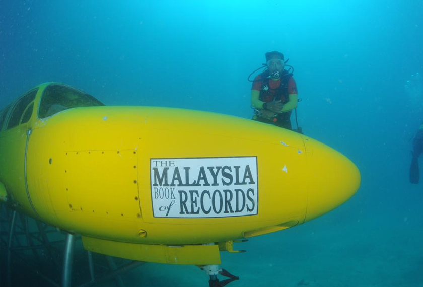 Penyelam turut bergambar di bahagian hadapan tukun kapal terbang yang memaparkan logo Malaysia Book of Records (MBOR) - Foto/PPTD