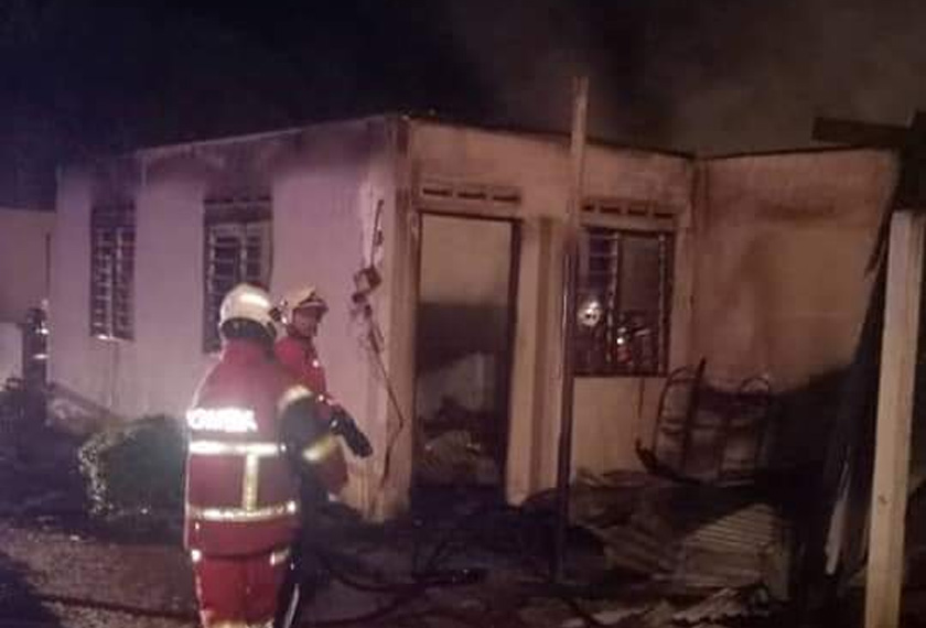 Anggota bomba dan Penyelamat dari Balai Bomba Kuala Lipis dan Sungai Koyan sedang memadamkan api rumah PPRT milik Muhamad Azli Ahmad dalam kejadian kebakaran di Kampung Bukit Betong, Lipis. - Foto ihsan JBPM