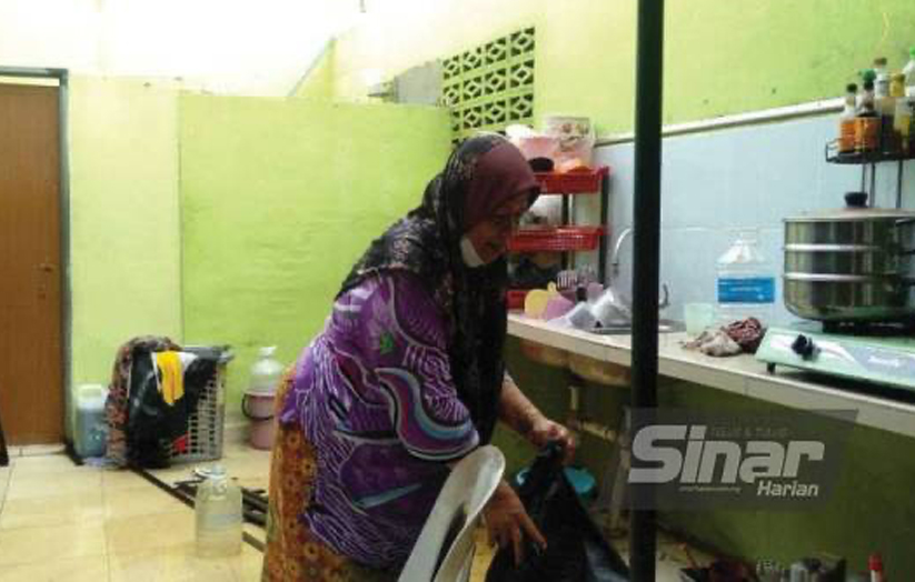 Noorazaliah membersihkan bahagian dapur rumahnya di Lorong Pengkalan Gelong, Titi Gajah, Alor Setar selepas kejadian ribut pada petang Ahad.