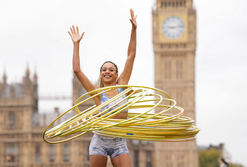 Mariam Olayiwola, also known as Amazi, attempts to break the Guinness World Record for spinning the most hula hoops simultaneously whilst on stilts, in London, Britain, November 10, 2022. - REUTERS