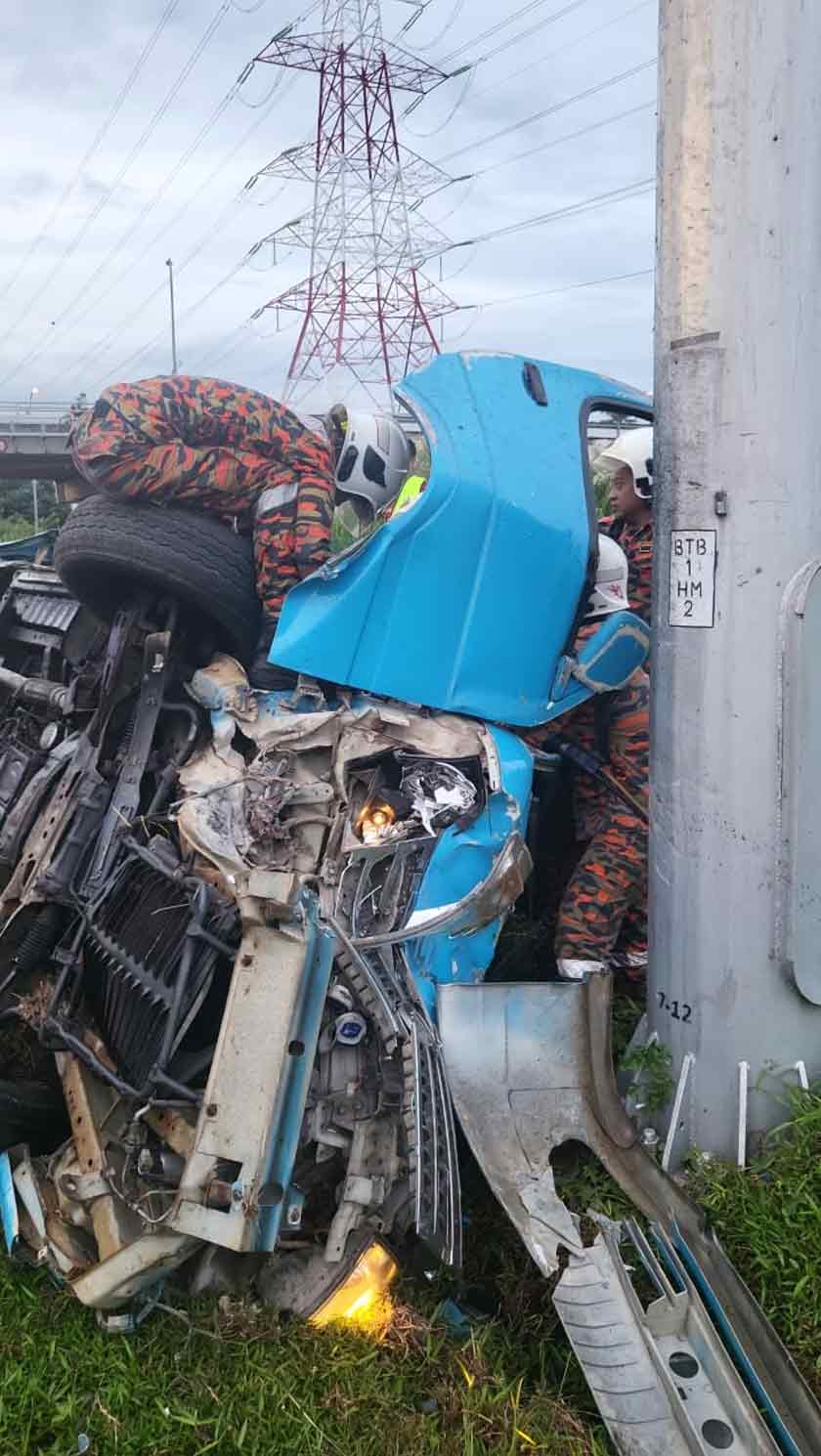 Anggota bomba ketika berusaha mengeluarkan mangsa dari van terbabit. - Foto JBPM