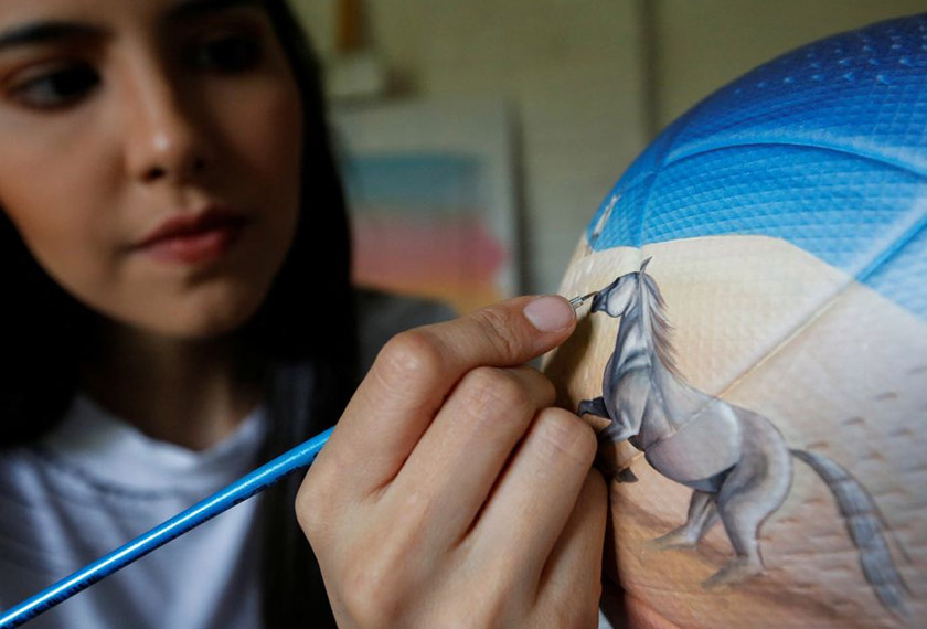 Lili Cantero paints a soccer ball ahead of the 2022 FIFA World Cup, in San Lorenzo, Paraguay. - REUTERS