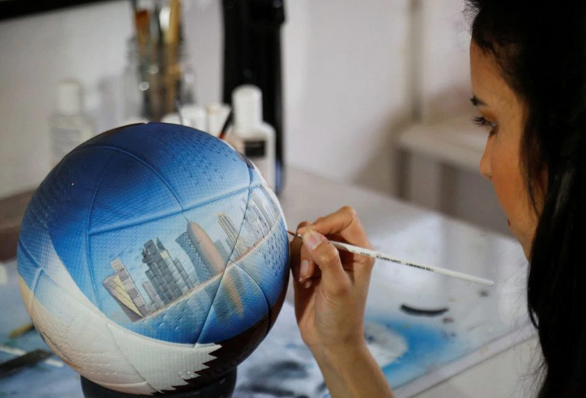 Paraguayan artist Lili Cantero, 29, paints a soccer ball with the skyline of Doha, Qatar, ahead of the 2022 FIFA World Cup, in San Lorenzo, Paraguay. - REUTERS