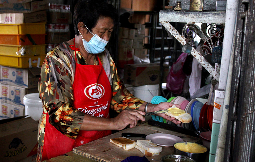 Pembantu kedai Ah Ling menyediakan roti ban bakar yang disapukan dengan marjerin dan kaya untuk pelanggan Restoran Double Lion, Kuala Kangar ketika ditemui baru-baru ini. --fotoBERNAMA