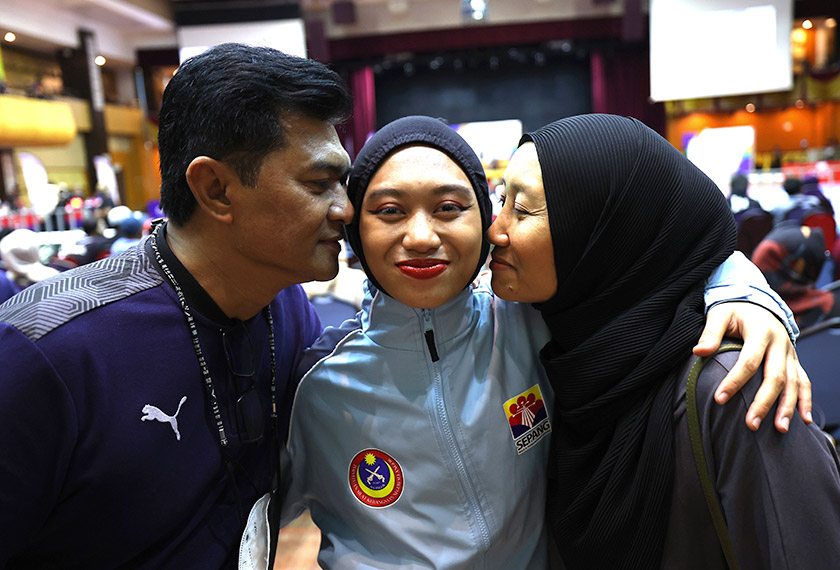 Mirsha Nurathiqa (tengah) bersama ibu bapanya selepas memenangi pingat emas dalam acara sukan silat akhir kategori Solo Kreatif pada Sukma MSN 2022 di USIM, Nilai, semalam. -- fotoBERNAMA