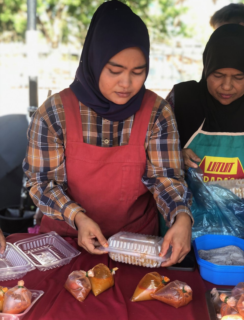 Halim Shaari dibantu isterinya, Adidah Awang Tengah dan anak perempuan, Nur Sabariah Halim menjual nasi daging kawah ‘Pak Teh’ di Bazar Ramadan Pendang, Kedah. - Gambar Astro AWANI