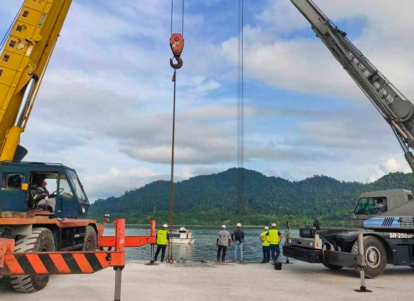 Dua unit kren dari pelabuhan dalam tindakan untuk membawa naik lori ke tebing. - Foto Bomba Perak/Sinar Harian