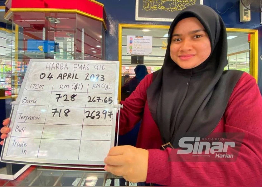 Nur Amalin Aisyah menunjukkan harga emas yang dijual di kedainya di Kota Bharu.