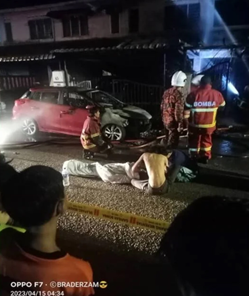 Anggota bomba dan orang awam membantu seorang mangsa yang terlibat dalam kebakaran tiga rumah di Taman Kota Masai, Pasir Gudang, pada Sabtu. - Sinar Harian